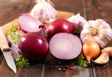 fresh red onion, garlic on wood background